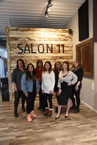 The Salon 11 team standing together in front of the Salon 11 sign